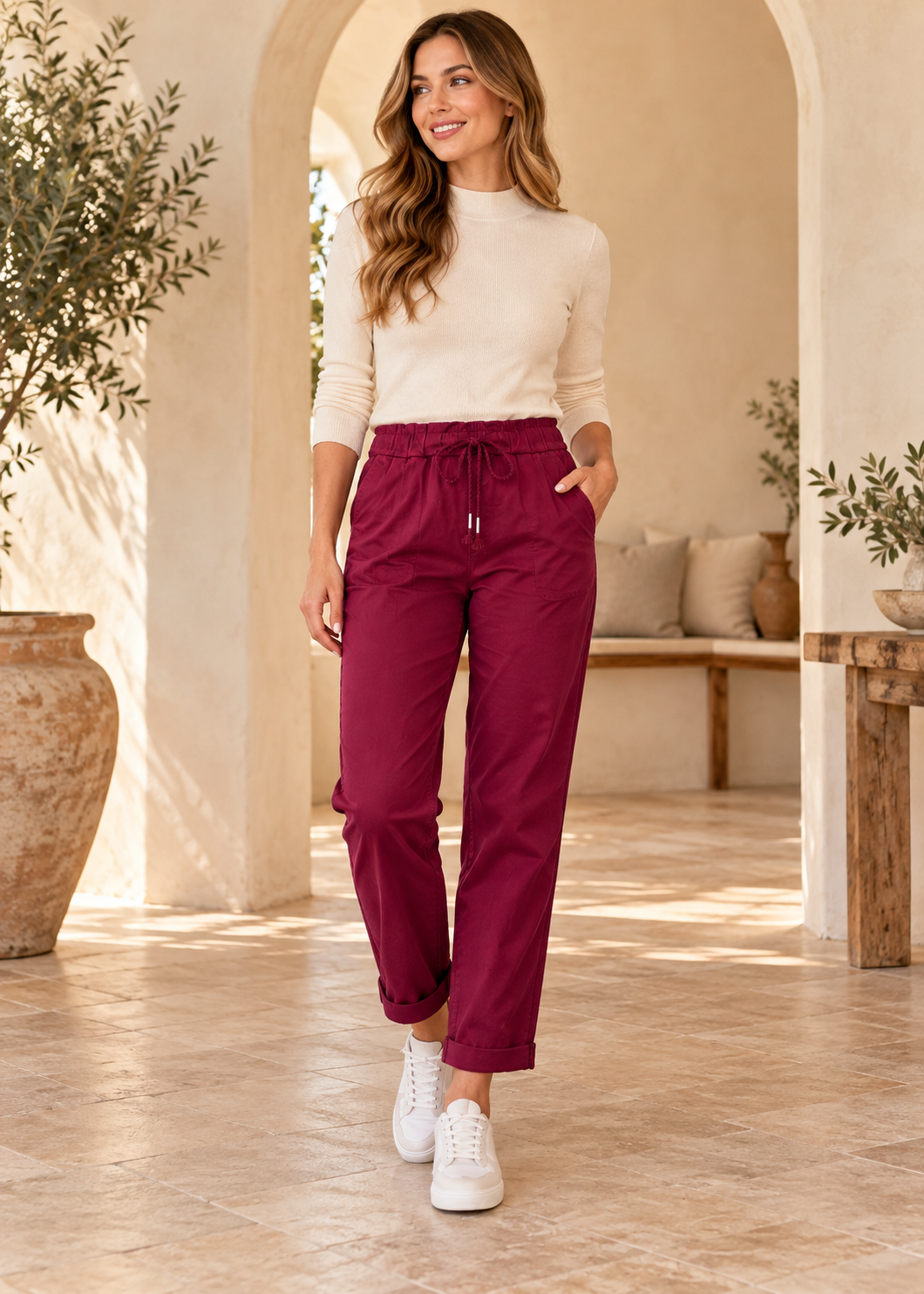 Italian Magic bi-stretch drawstring pants in wine burgundy, model wearing rolled hems and white sneakers