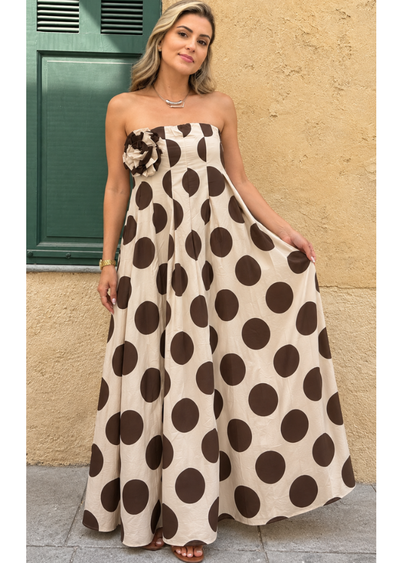 Modelo con vestido largo beige de lunares marrones grandes y flor de tela