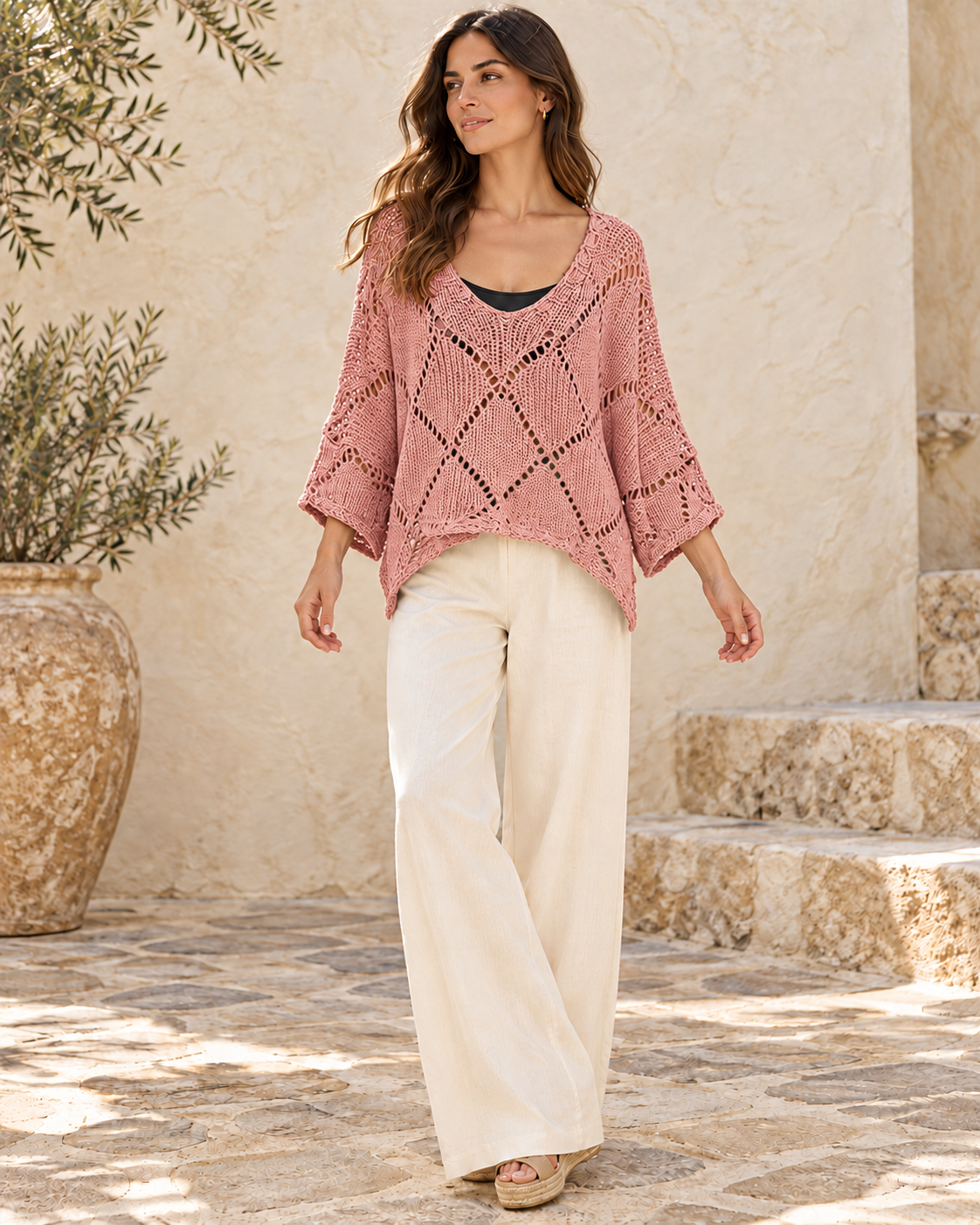 Pink cotton crochet knit pullover styled with ivory trousers