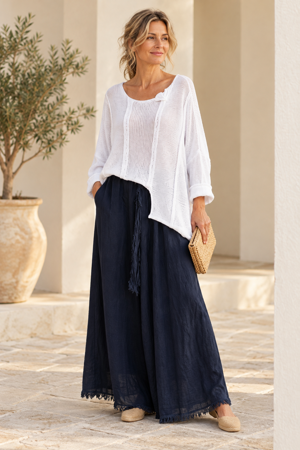White Italian cotton poncho sweater on a model, showing asymmetric front hem and folded neckline detail